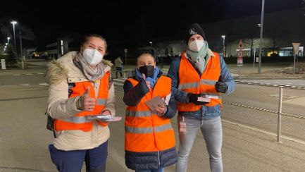 Menschen in Warnwesten verteilen Flyer zum internationalen Frauentag bei BMW